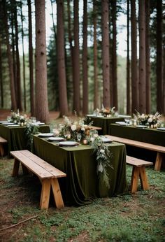 an outdoor table set up with green linens and greenery