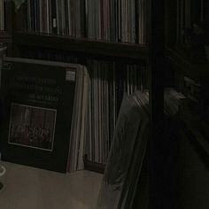 an old record player sitting in front of a book shelf