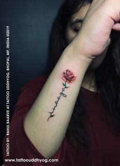 a woman's arm with a rose tattoo on it