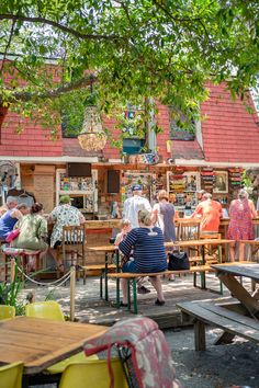 many people are sitting at tables outside in the sun