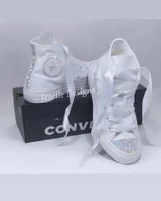 Bling CONVERSE CHUCK TAYLOR HIGH TOP in all white, canvas. *DESIGN for this listing: 💎 These Custom Jeweled Chucks Shine like DIAMONDS with CRYSTAL CLEAR premium rhinestones 💎 TOES completely covered in clear gems 💎 HEELS with 3 rows of crystals down the back 💎 Crystals on the logos on the inner 2 sides - around the circle and the star 💎 Small laces loop blinged out as shown on top of tongue 💎 Comes laced with beautiful white ribbon, with original laces included in the shoebox 💎 A personalization on the two outer sides, such a a name (as shown), dates, scattering crystals on the sides..  Some more detailed personalization may be an additional fee.   Message if you'd like to confirm and discuss your design.  *NOTE about crystal color: The color shown above has an iridescent color cal Converse Quinceanera Shoes, Quince Converse, Bedazzled Converse, Sparkle Converse, Personalized Converse, Rhinestone Converse, Bridal Converse, Converse Wedding Shoes, Converse Hi