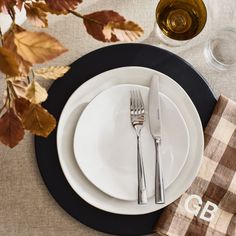 a table set with plates, silverware and wine glasses