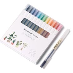 an assortment of markers and pencils on top of a white box with a plant in the background