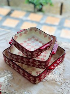 three red and white dishes sitting on top of a table