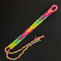 a pink, yellow and blue braided rope with a knot on it's end