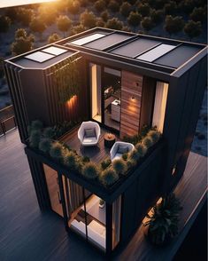 an aerial view of a modern house in the middle of trees and bushes at sunset