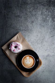 a cup of coffee and a doughnut on a napkin