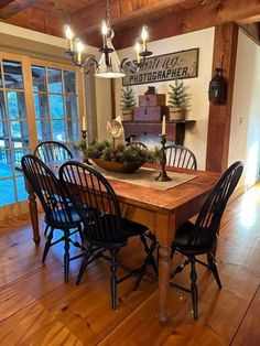 a dining room table with four chairs and a centerpiece on top of the table