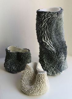 two vases are sitting next to each other on a white counter top, one is made out of yarn