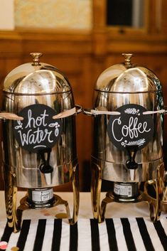 two silver coffee pots sitting on top of a table