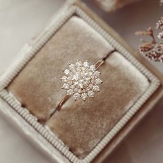 an engagement ring sitting on top of a velvet box next to some baby's breath flowers