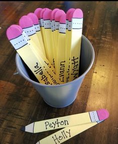 a bucket full of pencils sitting on top of a wooden table