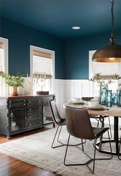 a dining room with blue walls and wooden floors