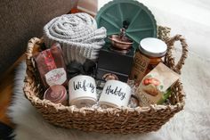 a wicker basket filled with coffee, tea and other items sitting on a rug