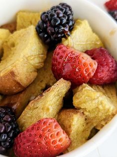 a bowl filled with bread and berries on top of a table