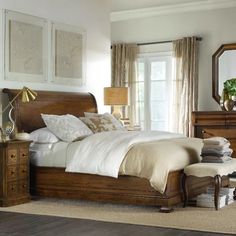 a bedroom with a bed, dressers and mirror in it's center area