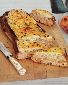 a wooden cutting board topped with meat and bread