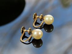 Presented is a classy pair of pearl stud earrings, with 14 karat yellow gold backs. These earrings are of American make and date to around the 1950s-1960s, though pearls are of course timeless. Each earring is securely set with a beautiful pearl of about 7.3-7.4 millimeters in diameter. The pearls have a wonderful rosy look, with pink and gold highlights. These earrings have screw style backs, suitable for wear with pierced or unpierced ears.     These earring screwbacks are stamped 14k. All par Vintage Round Pearl Earrings For Anniversary, Classic Pearl Earrings For Formal Occasions, Classic Formal Pearl Earrings, Classic Yellow Gold Pearl Earrings With High Luster, Classic Round Clip-on Earrings With Pearl Drop, Classic Round Pearl Drop Clip-on Earrings, Vintage Yellow Gold Pearl Earrings For Formal Occasions, Classic Clip-on Pearl Drop Earrings, Yellow Gold Vintage Pearl Earrings For Formal Occasions