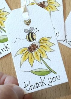 someone is holding up some thank tags with bees on them