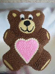 a crocheted teddy bear with a heart on its chest