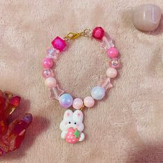 Kawaii cute pastel bracelet with strawberry bunny charm! Playful Pink Jewelry For Easter, Cute Beaded Bracelets For Birthday, Handmade White Kawaii Charm Bracelet, Cute Handmade Easter Jewelry, Cute Handmade Charm Bracelet For Friendship, Handmade Cute Charm Bracelet For Friendship, Pink Kawaii Beaded Bracelets For Birthday, Adjustable Pink Kawaii Charm Bracelet, Cute Handmade Beaded Bracelets