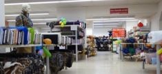 a store filled with lots of toys and stuffed animals in it's aisles next to bookshelves