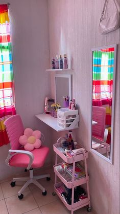 a pink chair sitting in front of a mirror on top of a desk next to a window