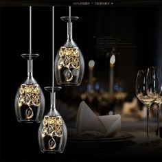 three wine glasses with lights hanging from them