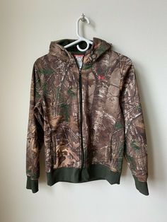 Up for sale is an Under Armour Storm Camo Hoody jacket size Medium.  This jacket is in EXCELLENT used condition with minor signs of use as can see from the pictures. Please email with questions.  This item will ship one day after payment is received.  Payment is required within 48 hours.  Thanks for looking!!   Here are the dimensions, please use these to ensure proper fit:   Chest from armpit to armpit:  19 inches   Length from top of shoulder to bottom: 25 inches Arm from armpit to end:  21 in Camouflage Sweatshirt For Winter Outdoor Activities, Camouflage Fleece Hoodie For Outdoor, Outdoor Camouflage Fleece Hoodie, Camouflage Hoodie Outerwear For Outdoor Activities, Camouflage Hoodie Outerwear For Outdoor, Fall Hiking Hoodie With Fleece Lining, Fall Outdoor Fleece Jacket With Kangaroo Pocket, Under Armour Hooded Sweatshirt For Streetwear, Under Armour Hooded Sweatshirt For Winter