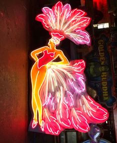 a neon sign that has a woman in a dress on it