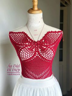 a dress on a mannequin with red crochet