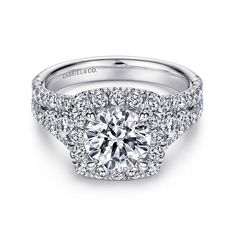 a diamond engagement ring with double halos on the sides and round diamonds in the middle