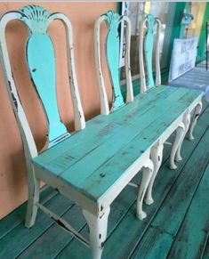 four chairs sitting on top of a wooden floor next to each other in front of a wall