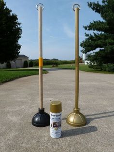 two metal poles are standing in the middle of a parking lot and one is holding a paintbrush