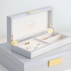 an open white box with two cufflinks in it and the words, adison ross london