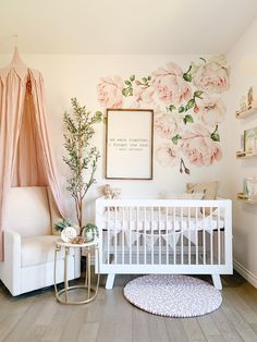 a baby's room with pink flowers on the wall and a white crib