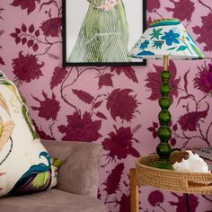 a living room with pink wallpaper and green lamp