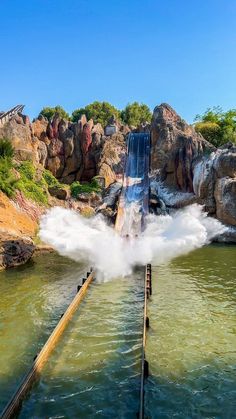 water gushing out from the top of a large pipe into a body of water