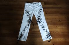 White and black lace up jeans, size Medium. ❤️DESCRIPTION: Reworked white jeans.  100% recycled.  Brilliant white jeans with grommets and lace up detail on both legs.  Lots of visual interest.  Perfect for your streetwear look! ❤️MEASUREMENTS: * size 10 Medium * 29 inch waist * 28 inch inseam * 100% recycled cotton, poly laces ❤️SHIPPING:  Immediate shipping worldwide; buy with confidence. ❤️MY SHOP: Click this link to see all the items in my shop:  www.TatteredEden.etsy.com Click this link to s Edgy White Denim Bottoms, White Edgy Jeans For Spring, Edgy White Jeans For Spring, Edgy Fitted White Jeans, Edgy White Fitted Jeans, Thigh High Leg Warmers, Work Sweaters, Belted Mini Skirt, Green Mini Skirt