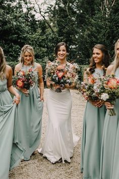 a group of women standing next to each other holding bouquets