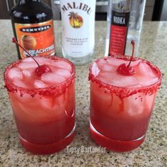 two red cocktails sitting on top of a counter