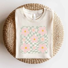 Looking for a cute versatile top to wear this summer? Make sure to grab one of our Wavy Checkered Flowers tees! This soft and comfortable graphic tee is the perfect top for any outfit. It can be paired with biker shorts, jeans, or even a simple skirt/dress! This tee is true-to-size, so be sure to order your regular t-shirt size! If you are looking for a more oversized look, make sure to size up! Mauve Blush, Flower Shorts, Purple Light, Green Grass, Ocean Blue, Ink Color, Sea Foam, Orange Pink, Ice Blue