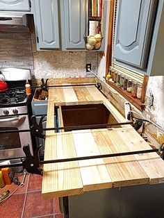 a kitchen with an island made out of wooden planks in the middle of it