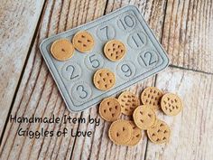 there are some cookies on the table next to a cookie sheet with numbers and holes