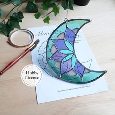 a stained glass sun catcher sitting on top of a piece of paper next to scissors