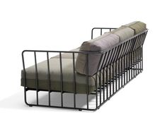 a metal sofa with two pillows on it's back and one arm folded down