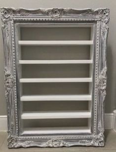 an ornate silver bookcase with white shelves