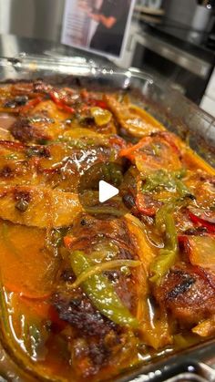 a casserole dish with peppers and meat in it sitting on a stove top