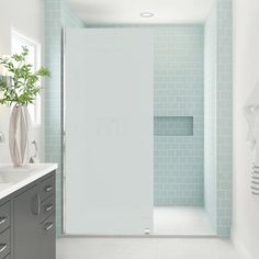 a bathroom with blue tiles and white walls, along with a large walk in shower