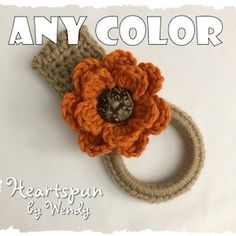 an orange crocheted flower is on top of a knitted headband with the words, any color